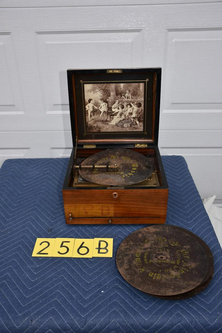 Polyphon 9-1/2" disc music box. 9-1/2" disc: Single comb. No broken teeth. 15 discs. Original lithograph. Ratchet wind.