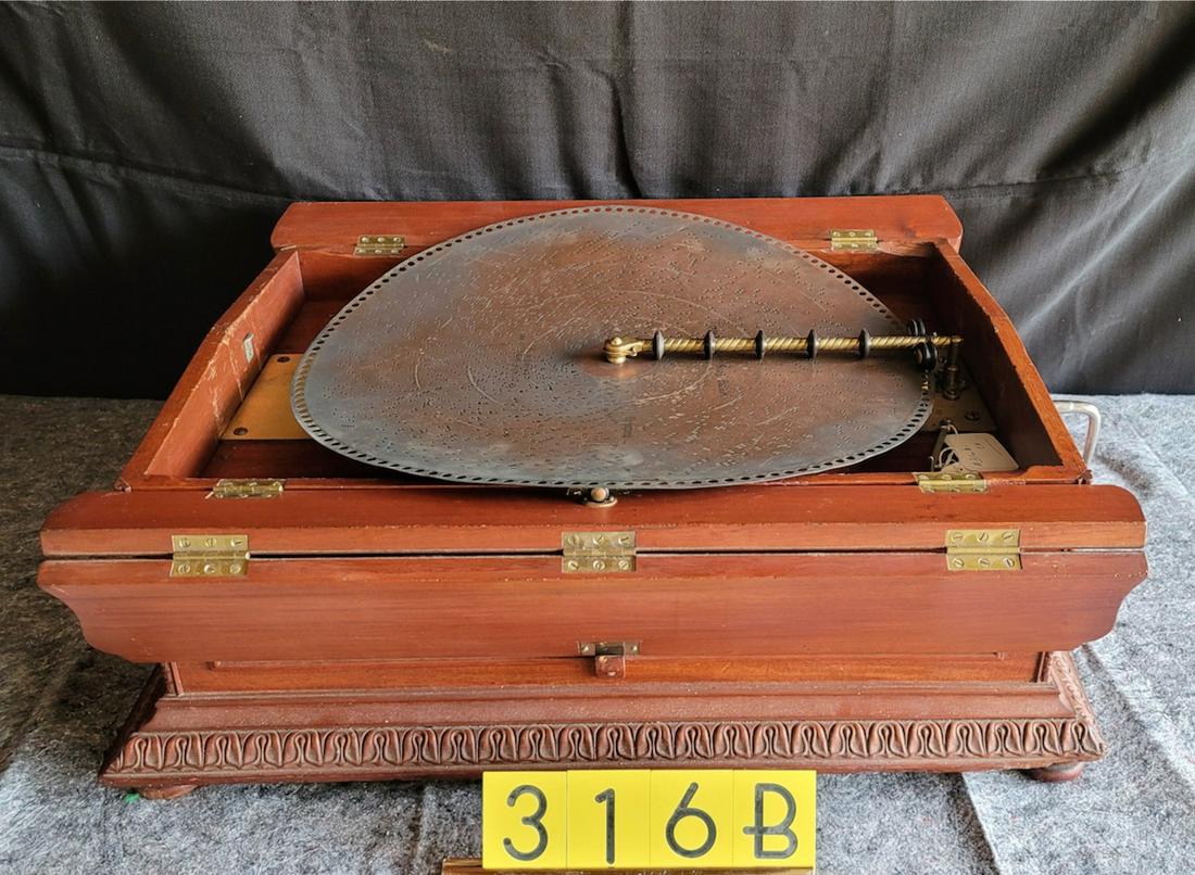 Regina Casket Model (flip top) music box: Mahogany case. 20-3/4" disc machine. 6 disc including. Double comb with no broken teeth. Needs some work