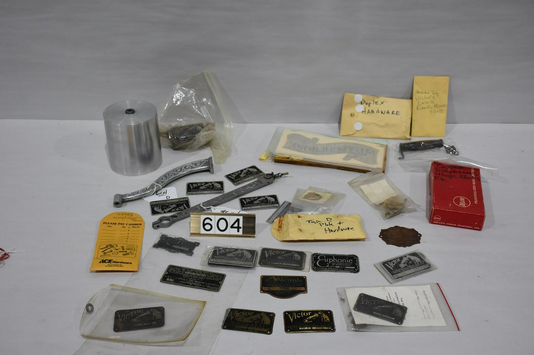 Group of phonograph parts: Columbia recast horn support and tone arm; Box lot of hardware, decals, machine plates, and a recast aluminum 5" mandrel for a Columbia AB McDonald machine