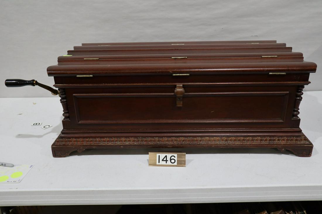 Regina Casket or Flip-top Model 7 Disc Music Box: An excellent example that plays a 27" disc. Mahogany. 10 discs included with the machine. No broken teeth SN-31128. Shipped from factory on Oct. 1901. SN-31128. Cabinet measures 33" long, 19-1/2" deep