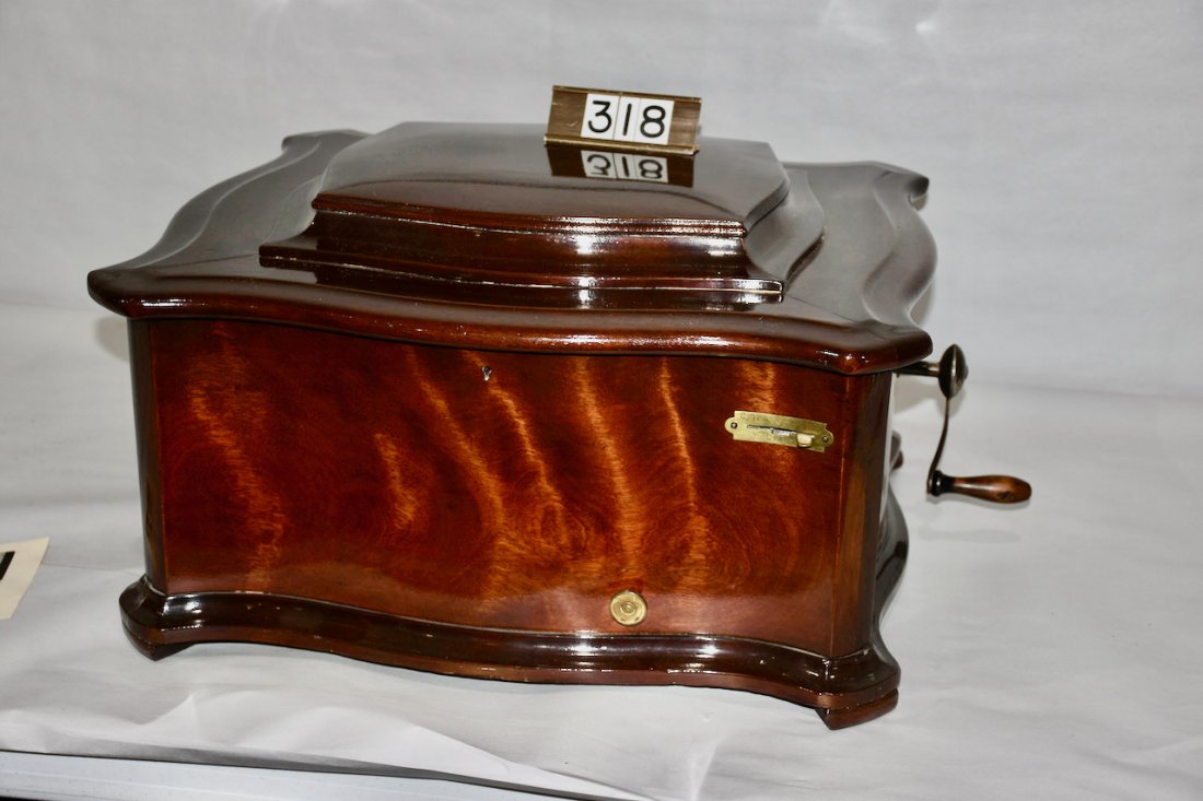Reginaphone 15-1/2" Music Box/Phonograph: A good combination Style 150 music box and phonograph. The music box is a mahogany serpentine case example and plays a 15-1/2" disc. Nickel panel horn. Complete with tone arm, reproducer and crank. In