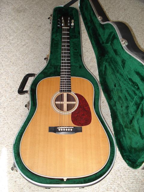 Martin HD-28 Acoustic Guitar: Has spruce top and rosewood body. SN-649055 (Ca. 1998), In lightly used condition with original strings still installed. Protective film over pick guard has not been removed. Includes martin Molded Ha