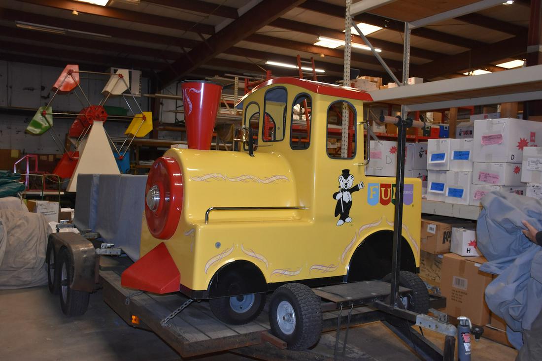 Trackless Train Ride: Manufactured by Royal Train Rides. Holds up to 18 passengers. Includes storage covers. On a trailer.