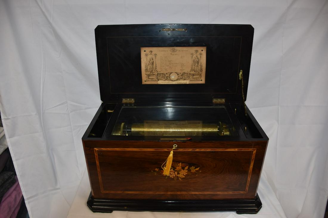 A wonderful Cylinder organ music box: Fabrique De Geneve. 12 tune with original tune card. The organ plays. The case is inlaid on the top and front and is in very good condition. 13" cylinder. The case measures 24" wide x 13" deep x 12" t
