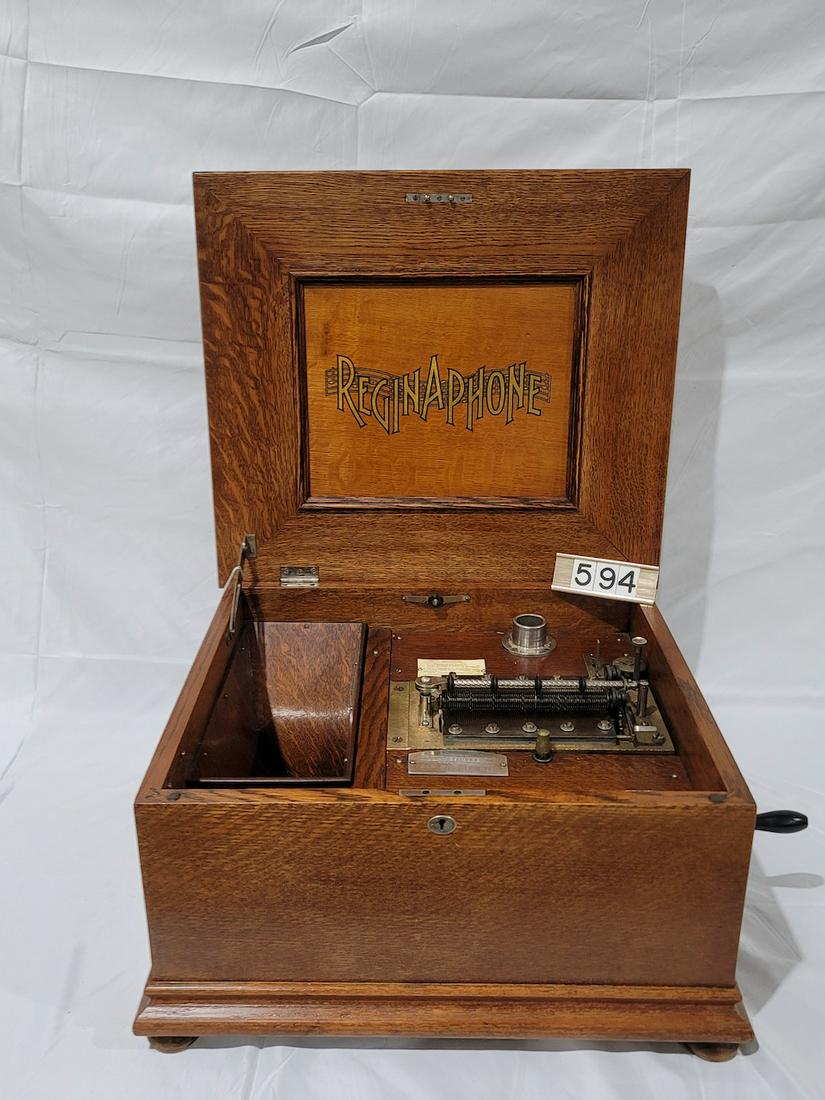 Reginaphone Disc Music Box: 15-1/2" disc. Double comb. No broken teeth. Inside horn. Oak case. SN-2510022. Very good condition. 12 discs. No turntable or tonearm and reproducer for the phonograph mechanism