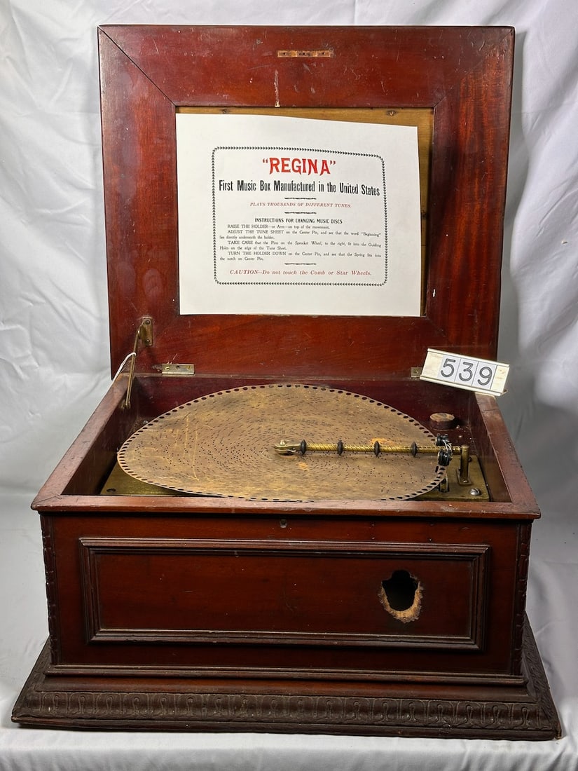 Regina 15.5" Disc Music Box: Mahogany case. Double comb, no broken teeth. New litho for cover. Plays. The coin mechanism is missing. One interior sound board is gone. One disc.