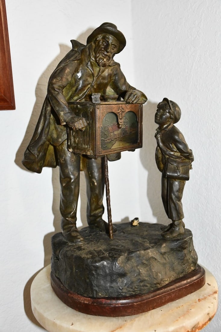 Bronze Statue of an Organ Grinder: The statue depicts an organ grinder playing a tune with a young boy listening intently. 9.5"x 7"d x 16"h