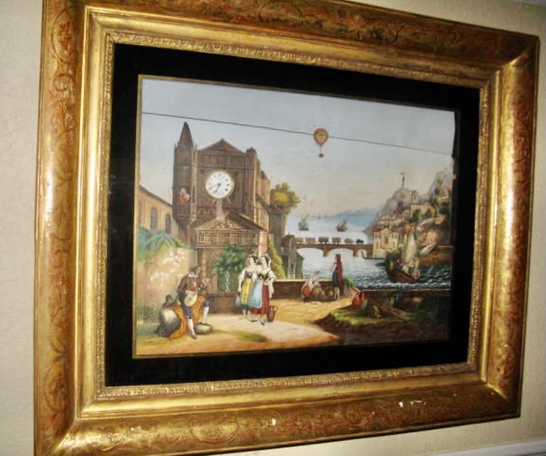 Large and Impressive Musical Painting: The large example houses a brass 6.25" cylinder music box, clock in the painted tower, etc. Housed in a large gilt deep box frame that lifts to expose the mechanism behind the same. one broken tooth(s