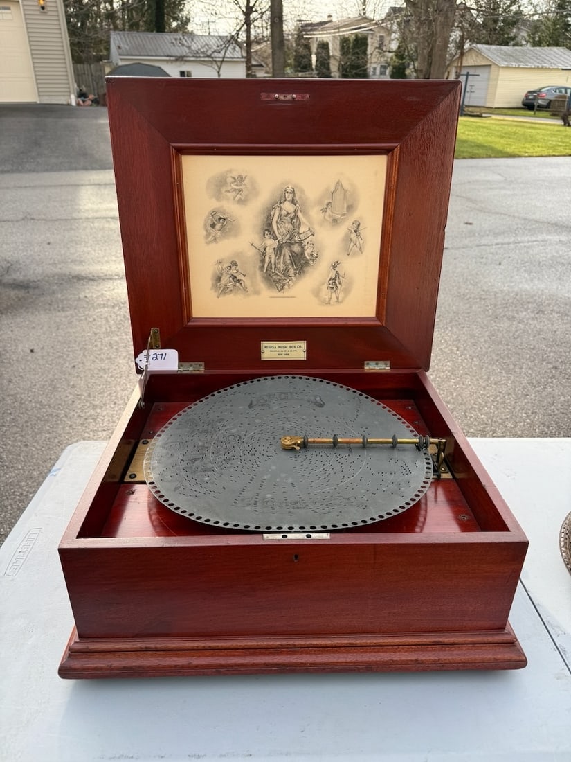Regina Disc Music Box: 15.5" machine. Single comb. No broken teeth. Mahogany cabinet with crank. 13 discs