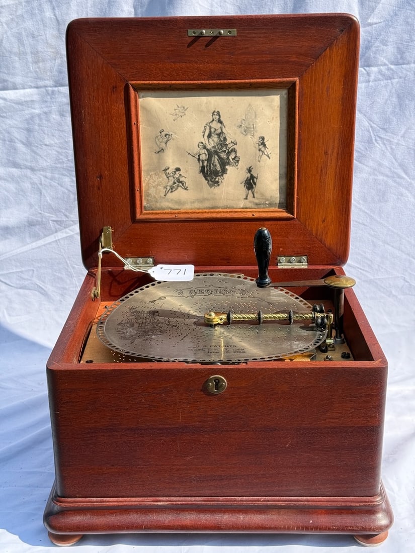 Regina 12-1/4" Disc Music Box: Mahogany, Style 16, Duplex combs, no broken teeth, 16-12-1/4" Disc Included. Palys. Case measure 16-1/2" x 15"d. 9.3/4"h.