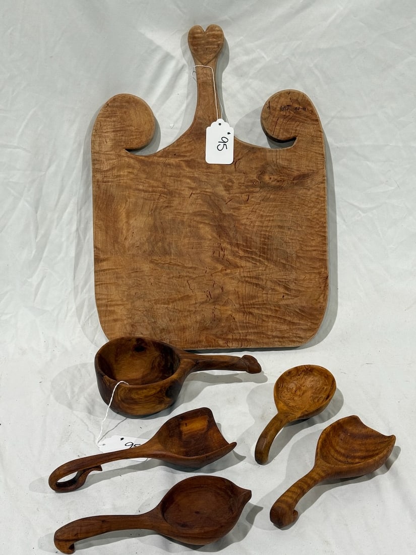 A group of carved wooden ware items: Cutting board, ladles and more. 6 pieces total