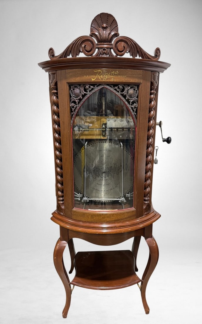 Regina Style 35 15-1/2" Automatic Disc Music Box Changer: Mahogany bow front case with clear glass front, double comb, good working order. 12 discs included. SN-3500203