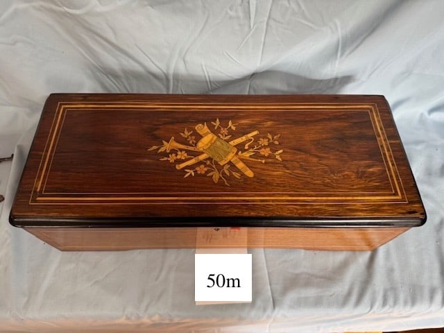 Cylinder Music Box D.H.& Co., London: 12 Tunes; Plays well w/Tune Card and Mandolin Attachment. No broken teeth. Inlaid cover with drum & instruments. Cylinder measures 10- 3/4”. The case measures 20” x 8” x 5-1/2”