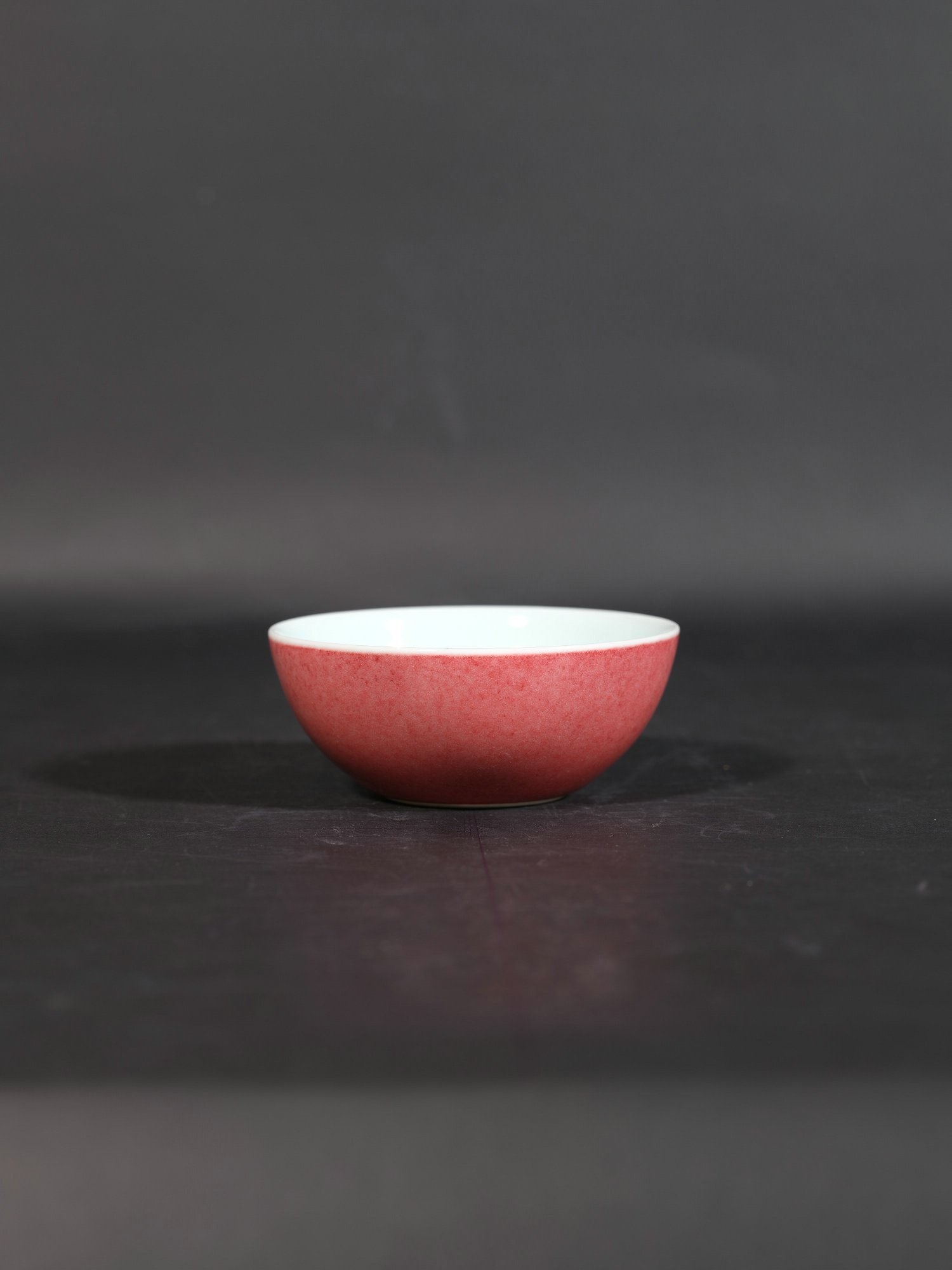 A red-glazed flat-footed cup: Height 3cm Width 8cm