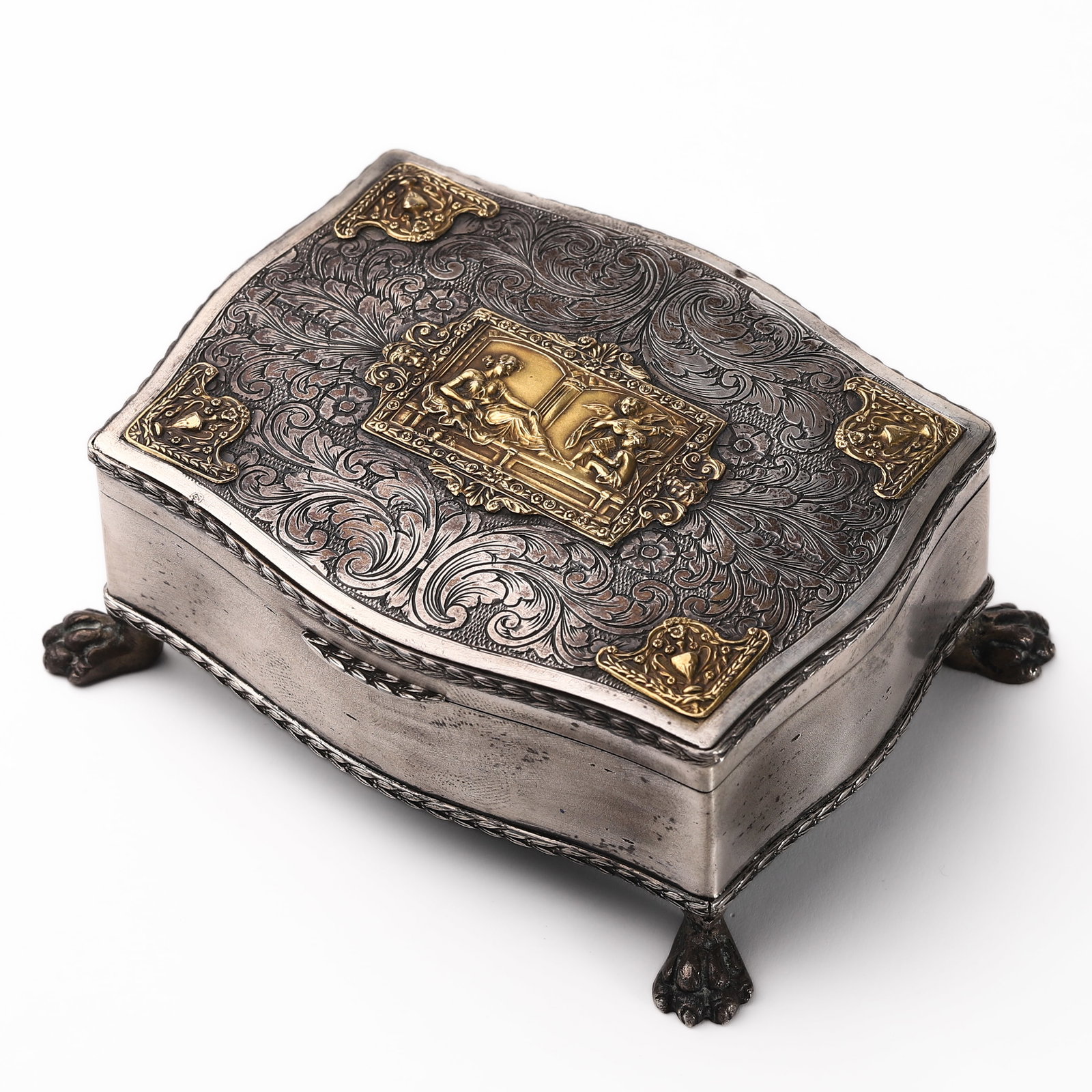 ANTIQUE SILVER AND GILT METAL JEWELRY CASKET: Dimensions: Length: 4 1/8 in. (10.5 cm), Width: 3 in. (7.7 cm), Height: 1 9/16 in. (4 cm), Weight: 4.5 oz (128.2 g). Description: This antique silver jewelry casket, raised on four claw feet,