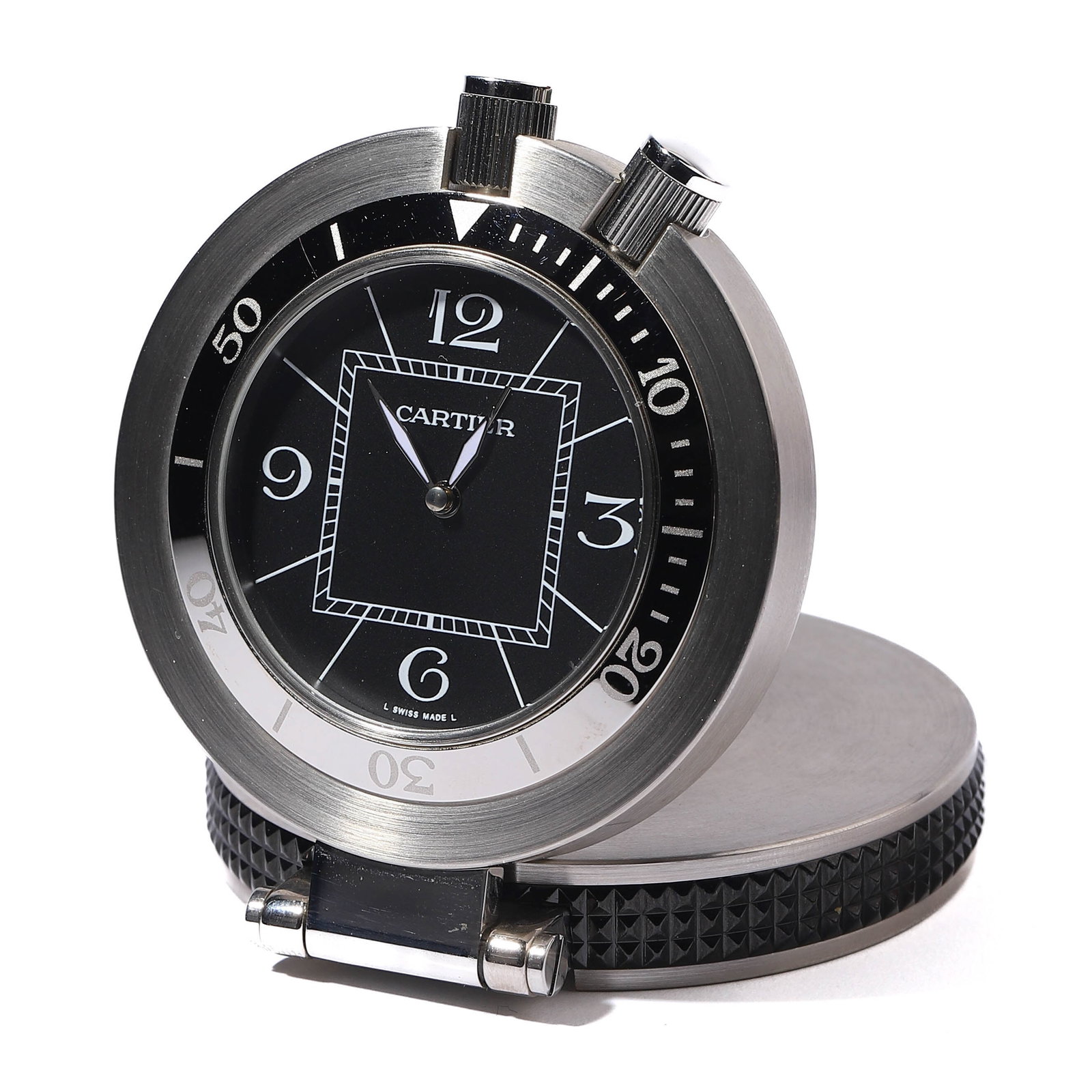 CARTIER TABLE CLOCK: diameter: 2 in (5.1 cm) A round Cartier table clock featuring a stainless steel body with a polished finish. The black dial is accented with white numeral markers and the Cartier logo. The back case i