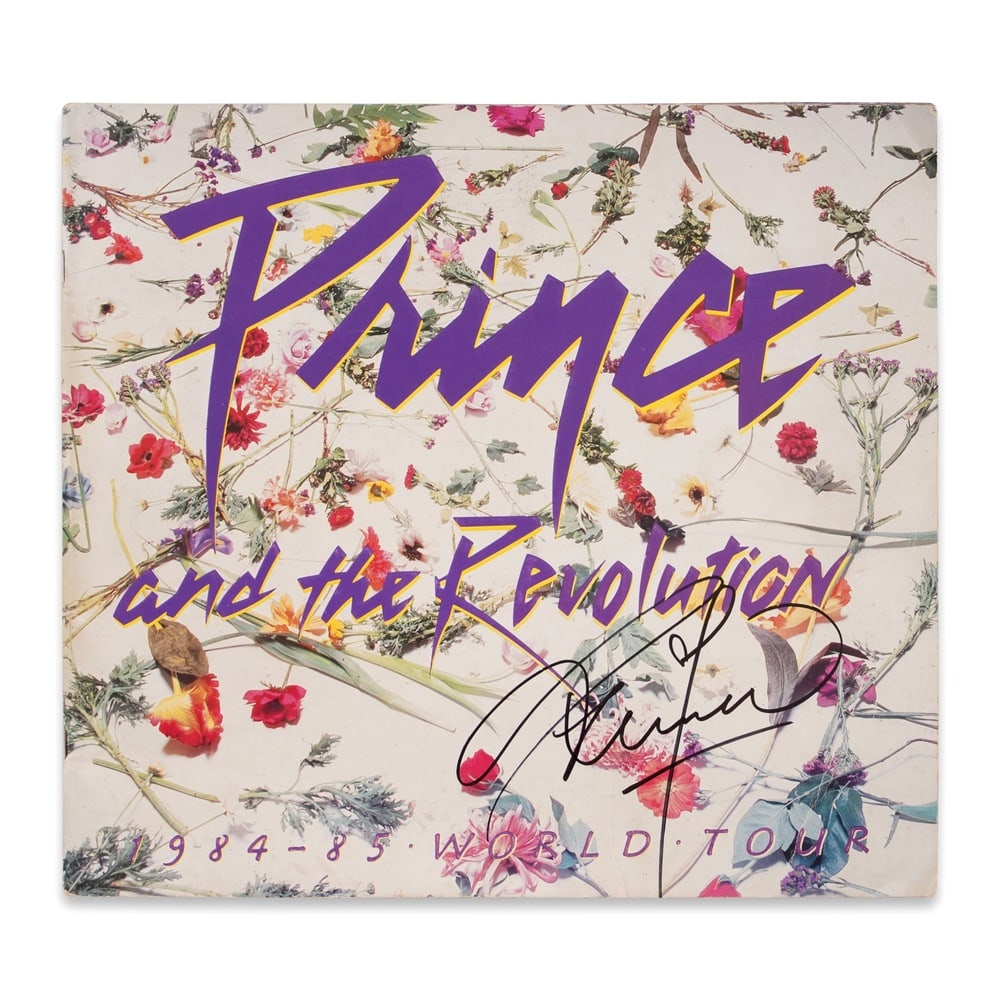 PRINCE SIGNED PURPLE RAIN WORLD TOUR PROGRAM (1984-1985): 13 x 12 in (33 x 30.5 cm) Provenance and Authentication: According to the Letter of Authenticity (LOA) and Certificate of Authenticity (COA) provided by the consignor, this collectible was subjected