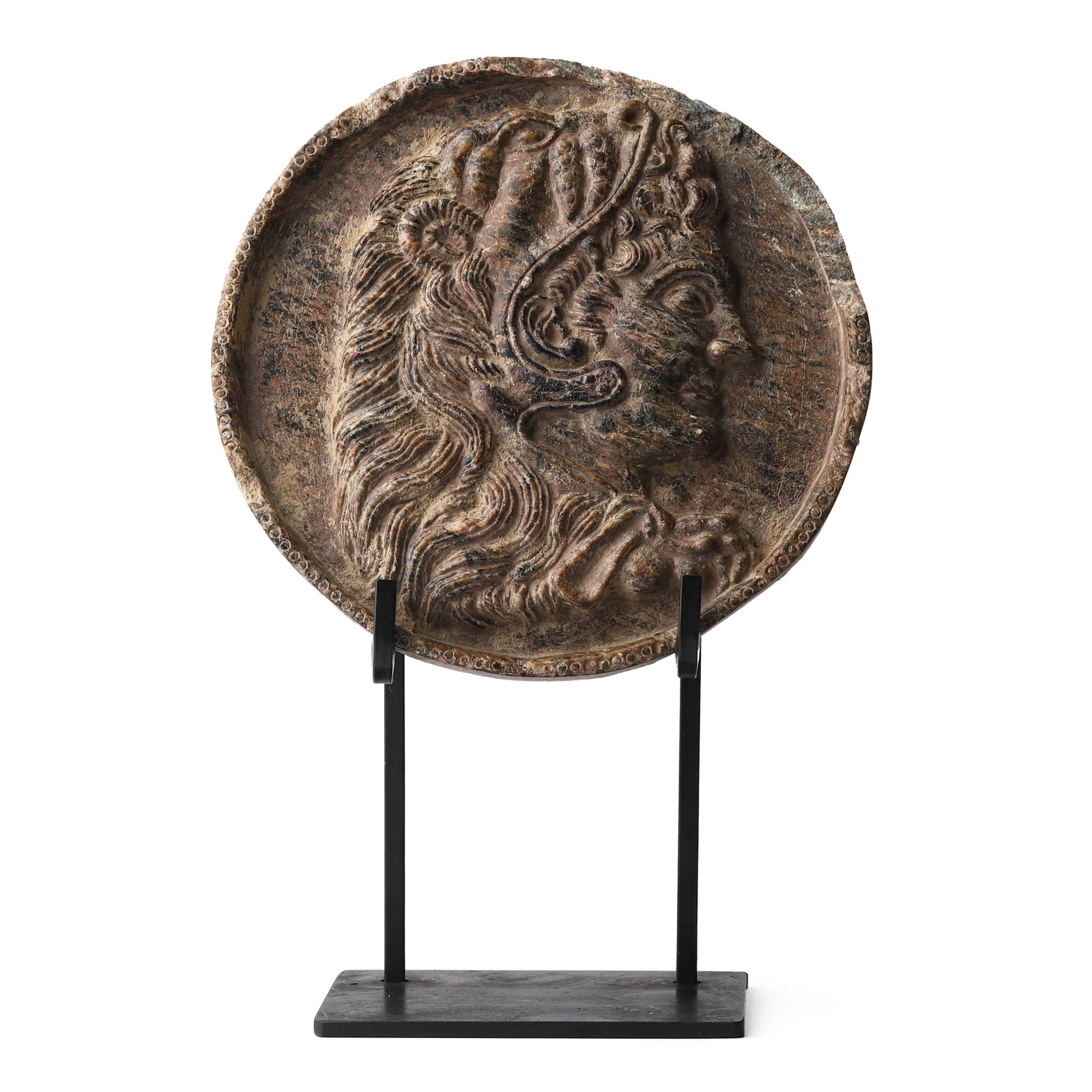 A STONE RELIEF MEDALLION WITH CLASSICAL PROFILE: Diameter: 6 1/8 in. (15.5 cm) Carved in high relief, this circular stone medallion features a classical profile portrait of a male figure wearing a crested helmet, possibly inspired by depictions of