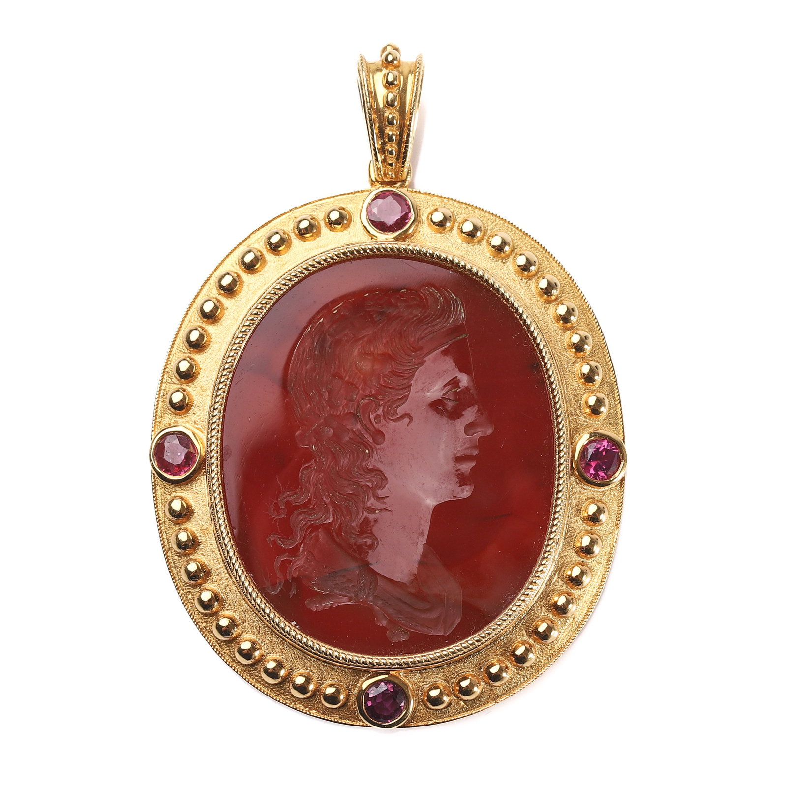 A 22K GOLD PENDANT SET WITH A CARNELIAN INTAGLIO AND RUBIES.: Dimensions Length 1 1/2 in (38 mm); width 1 5/16 in (34 mm); weight 12.5 g. Description The oval pendant is finely mounted in 22k gold, centering on a rich reddish-brown carnelian intaglio carved
