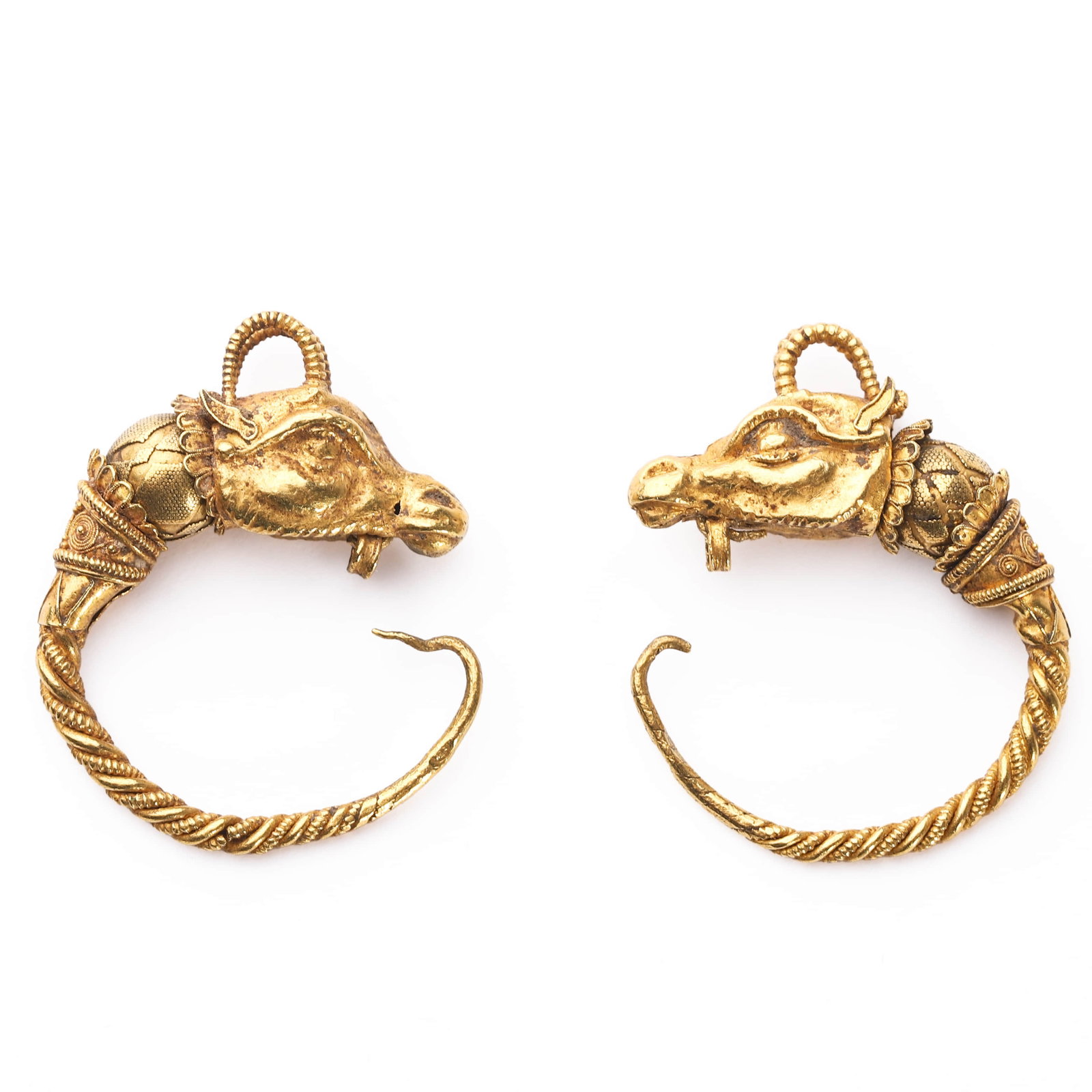 PAIR OF GOLD EARRINGS WITH ANIMAL HEAD TERMINALS: Dimensions:?Length: 1 1/8 in. (28.9 mm); Total Weight: 10 gA pair of traditional-style gold earrings featuring intricately modeled zoomorphic terminals in the form of stylized bovine or antelope