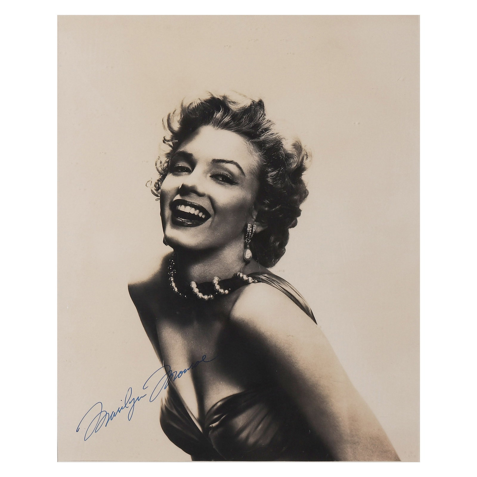 MARILYN MONROE PORTRAIT: Title: Marilyn Monroe Portrait Materials: Gelatin silver print, mounted on board Signature: Signed "Marilyn Monroe" in blue ink at the lower left Size: Photograph 11 3/16 × 14 in. (28.4 × 35.5 cm); 