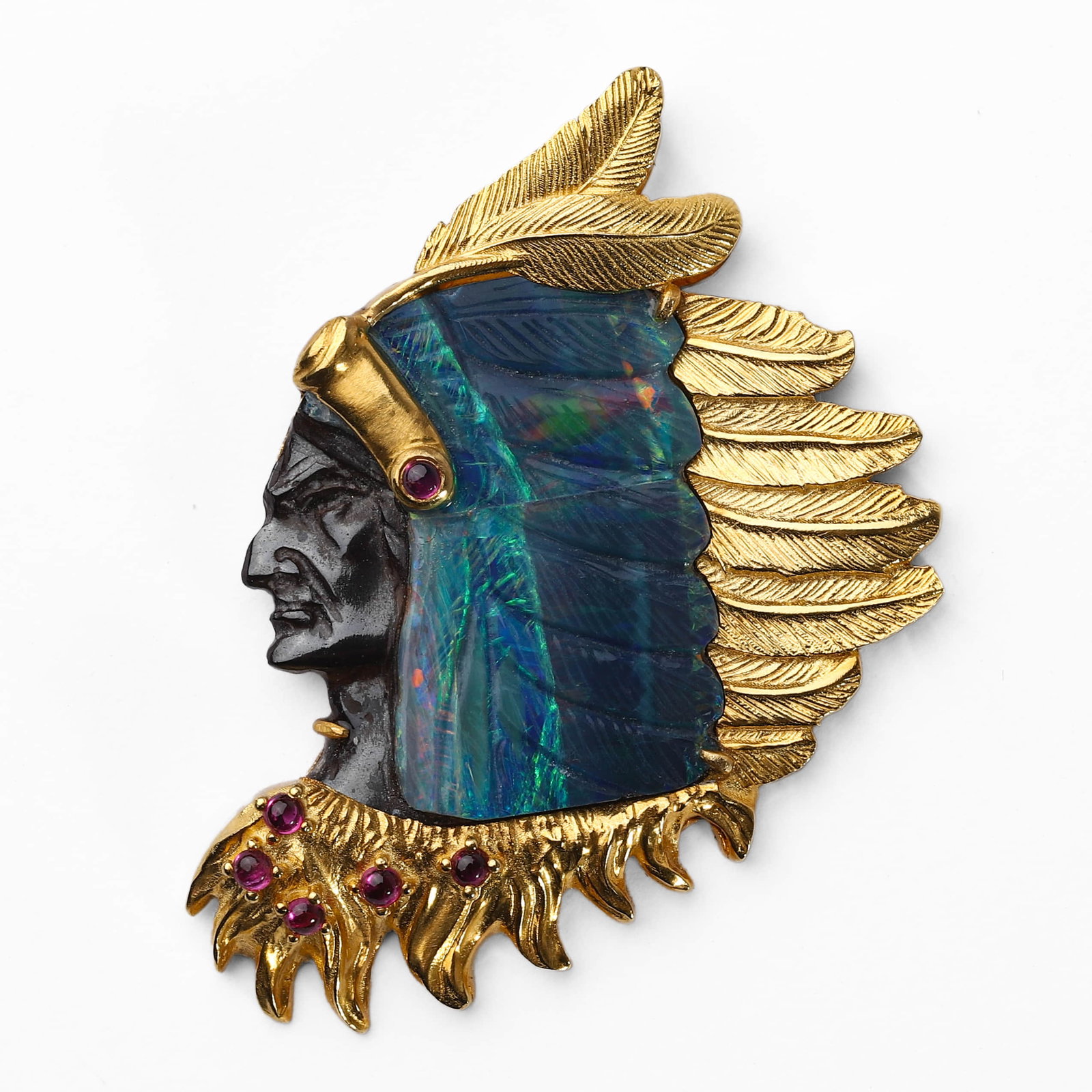 AN OPAL AND 18K GOLD BROOCH, "KING OF THE INDIANS": Dimensions Length: 1 7/8 in. (48 mm); Width: 1 5/16 in. (33 mm); Weight: 12.5 g Description Centering an opal cameo finely carved as the portrait of a Native American chief, enhanced by sculpted 18k g
