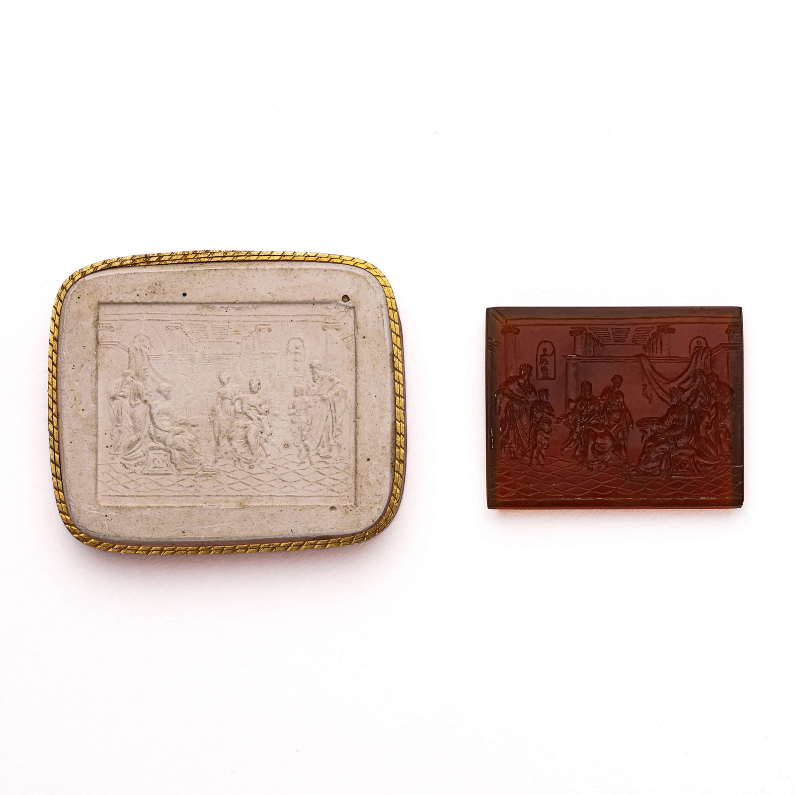 AN AMBER INTAGLIO PLAQUE: Dimensions: Length: 1 13/16 in. (46.7 mm), Width: 1 9/16 in. (39.9 mm), Weight: 16.4 g Description: A rectangular amber intaglio plaque finely carved with a neoclassical interior scene featuring