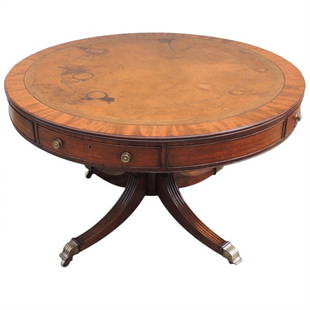 19th C English Regency Mahogany Rent Table: The base of this table is made of solid mahogany, while the top is constructed of mahogany and pine veneer with a brown leather writing surface. The leather top features a floral gold trim and has som