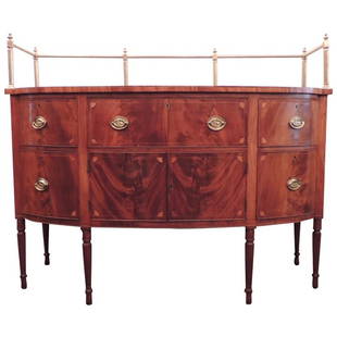 Early 19th C Sheraton Mahogany Sideboard with Gallery: This Sheraton sideboard was made in America circa 1810s, and features a brass gallery, five drawers, and a cabinet. The piece features lion pulls and reeded Sheraton legs.