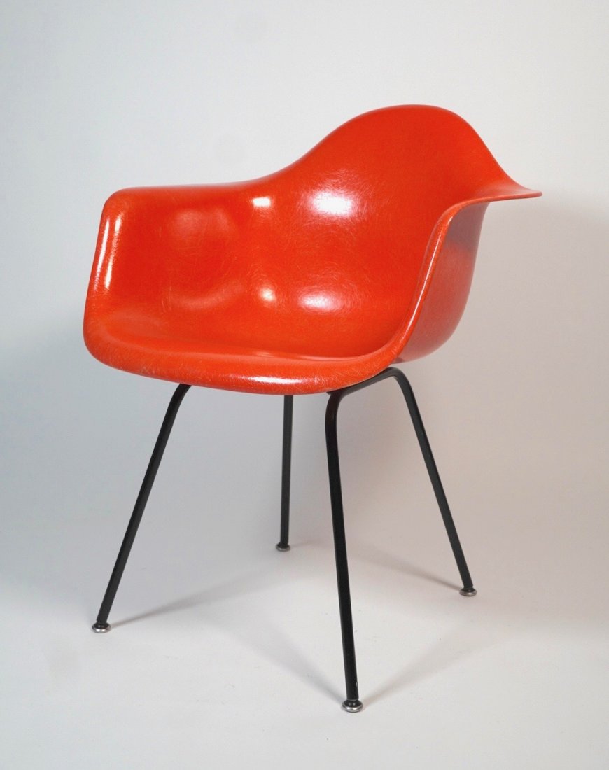 1960s Orange Eames Fiberglass Armchair: Vibrant colored 1960s Eames fiberglass armchair with interesting transitional glides labeled on bottom of chair, 31" tall by 24.5" wide by 22.5" deep[ with a seat height of 17".