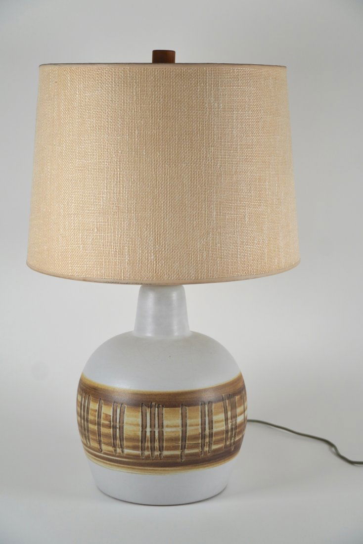 Jane and Gordon Martz Ceramic Table Lamp for Marshall Studios: All original Martz ceramic table lamp with shade having beige and brown hand painted glazes with both vertical and horizontal design patterns across the center of the lamp resting on a walnut base des