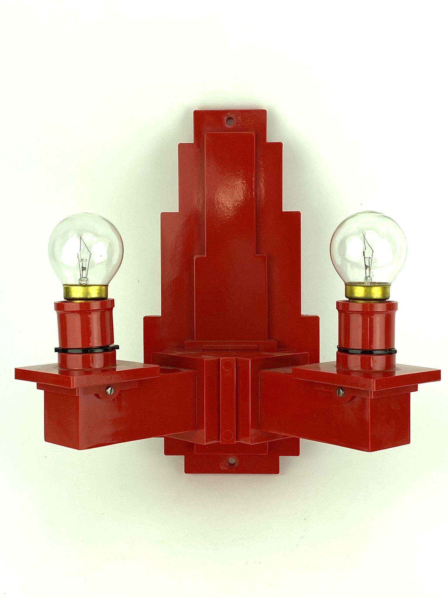 Art Deco Stepped Skyscraper Red Plastic Sconce: Marked made in England on backside. Red plastic or hard composite material - unknown maker or designer. Uses smaller than standard bulbs. Measures 10" x 10" x 6" deep.