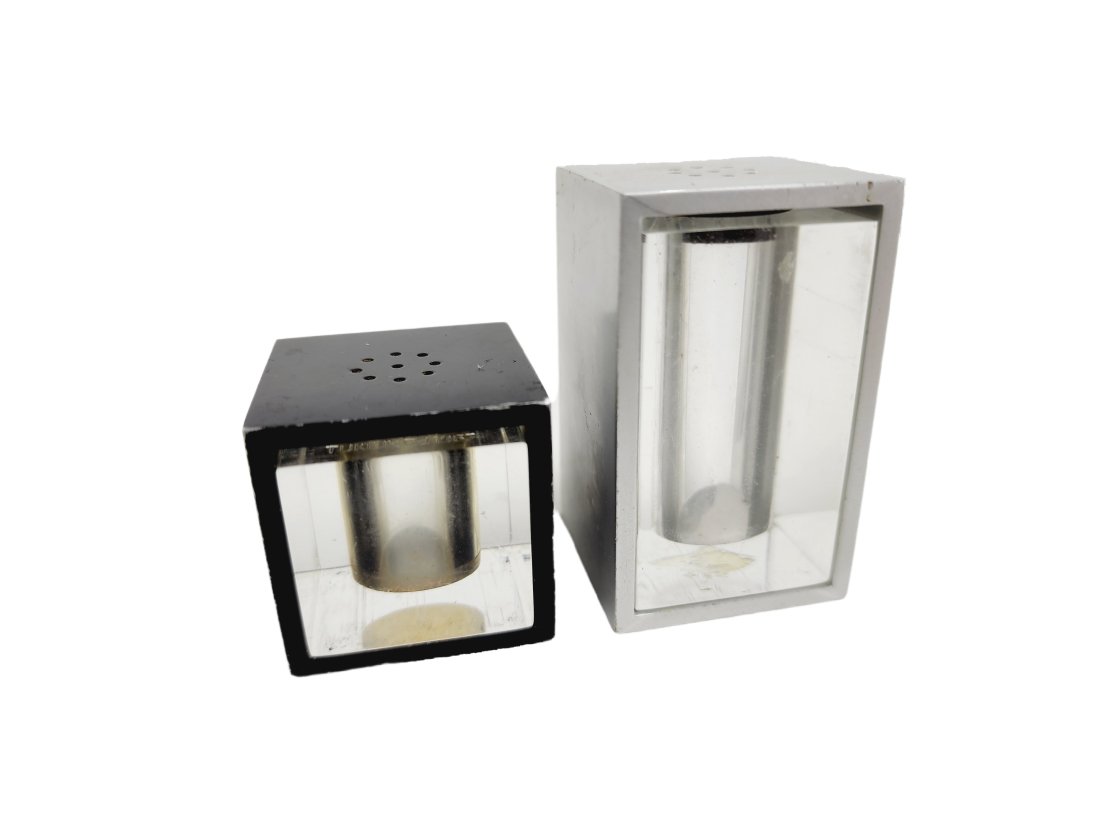 Marcel Girard 1967 Tukilik Modernist Salt & Pepper Shakers: Vintage Mid Century Modern 1967 Montreal Expo salt and pepper shakers designed by Marcel Girard for Danesco. Measure 1 3/4" to 2 5/8" x 1 3/4" wide in metal and acrylic.