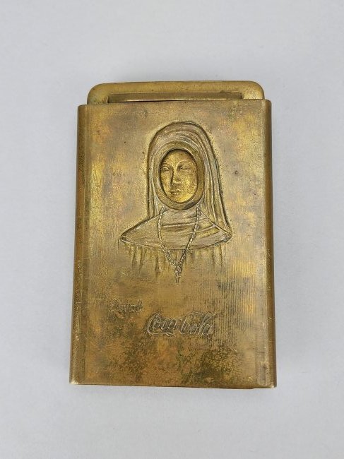 Coca-Cola Nude Woman Novelty Brass Belt Buckle: Unique Coca Cola branded brass belt buckle with portrait of Nun or Priestess. Center slides open to reveal a nude woman. Measures 2 1/2" x 4".