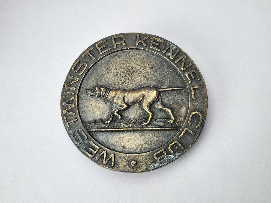 Westminster Kennel Club Vintage Brass Belt Buckle: Vintage round brass belt buckle with dog and Westminster Kennel Club Logo. Made by Tiffany Studios. Measures 2 1/2" diameter.