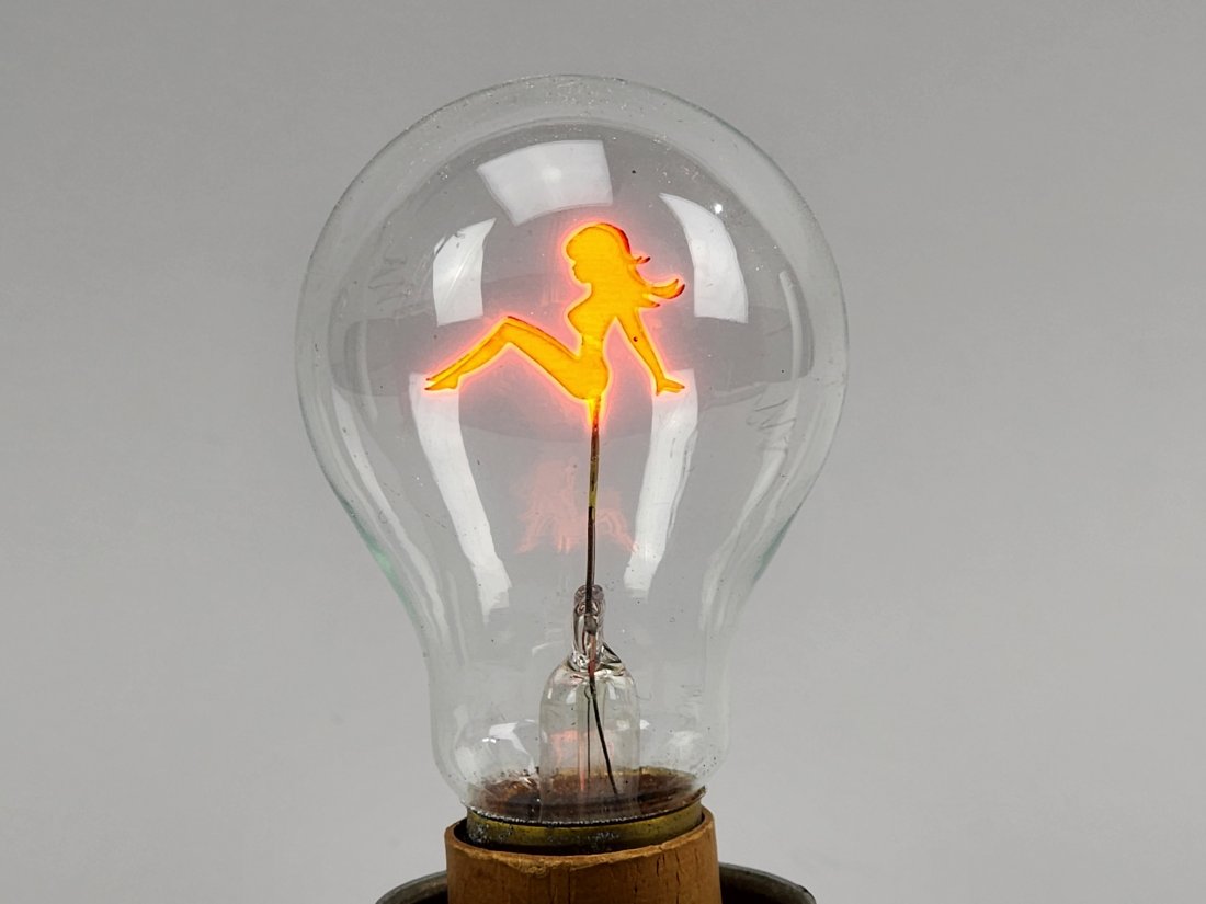 Vintage Aerolux Nude Pin-up Light Bulb: Vintage Aerolux nude woman iridescent light bulb - Art deco period. Lights up orange/red in center. Measures standard bulb size.