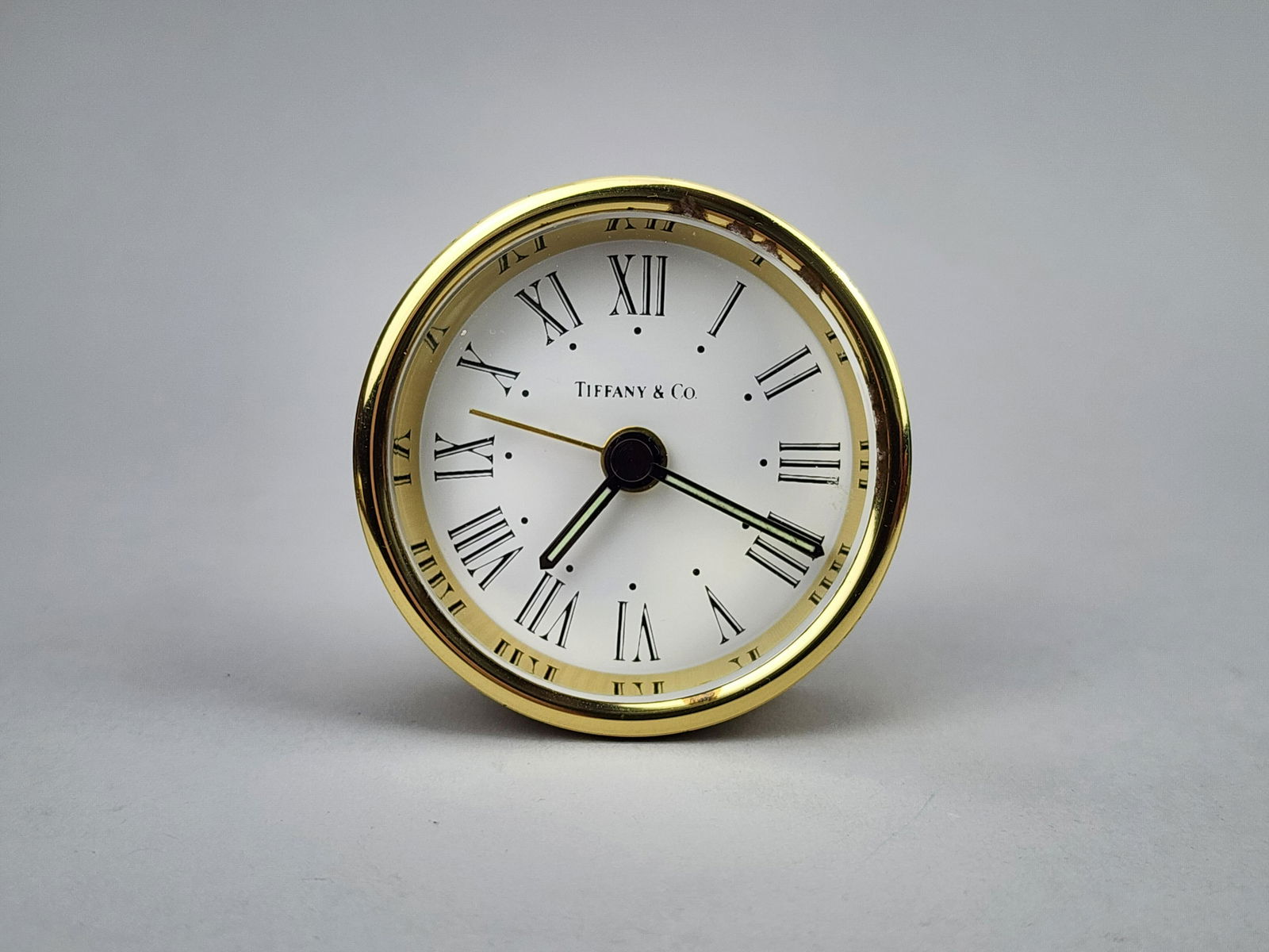 Vintage Tiffany & Co. Infiniti Brass Travel Clock: Vintage brass travel clock by Tiffany & Co. Infiniti model. Measures 2 1/2" x 1".