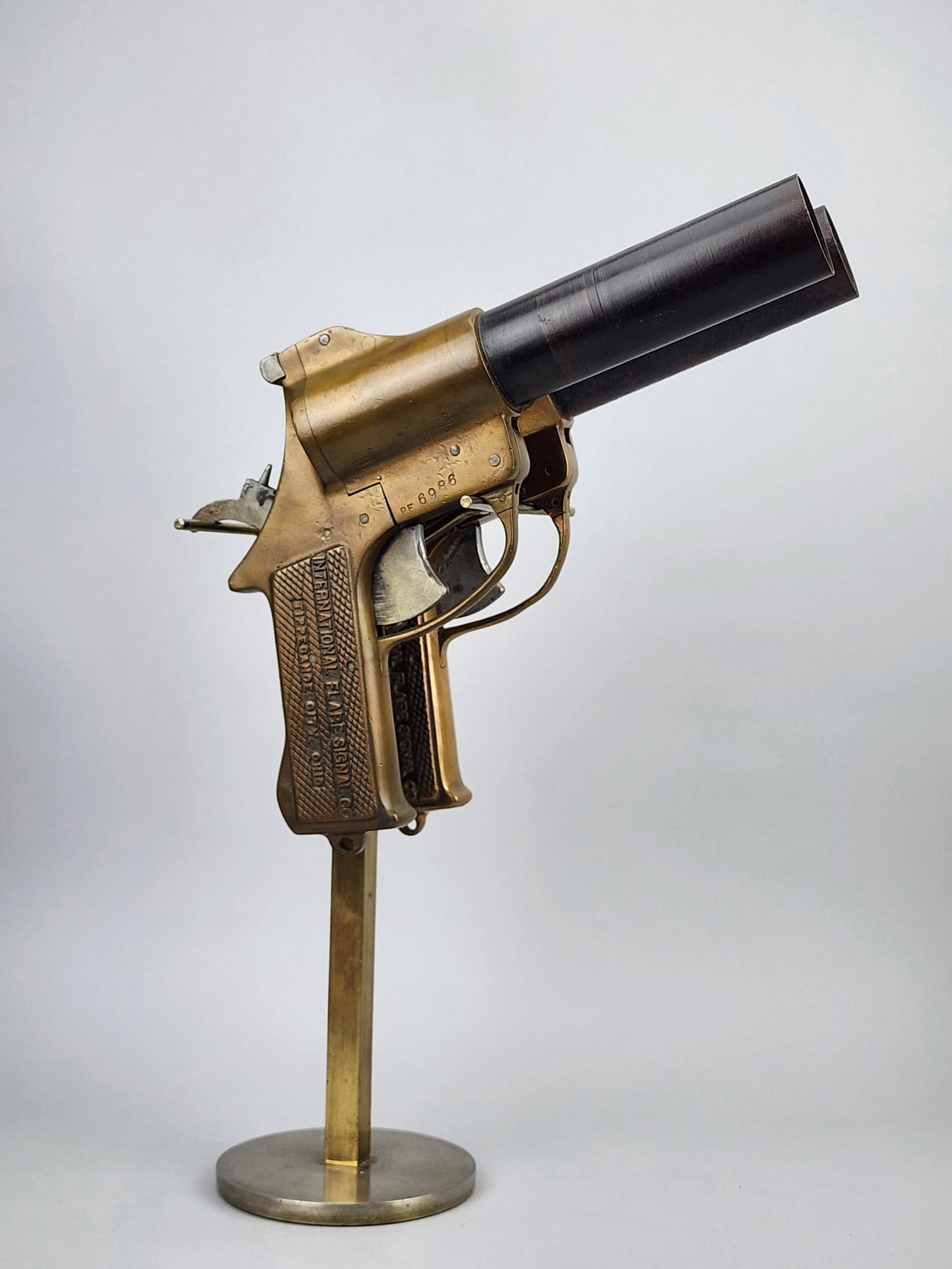 International Signal Flare Co. WWII Brass Flare Guns with Custom Display: Pair of brass flare guns for the WWII era by International Signal Flare Co. Includes custom display stand. Measures 16 1/2" x 11" x 6" total. 8" x 11" x 2" each gun.