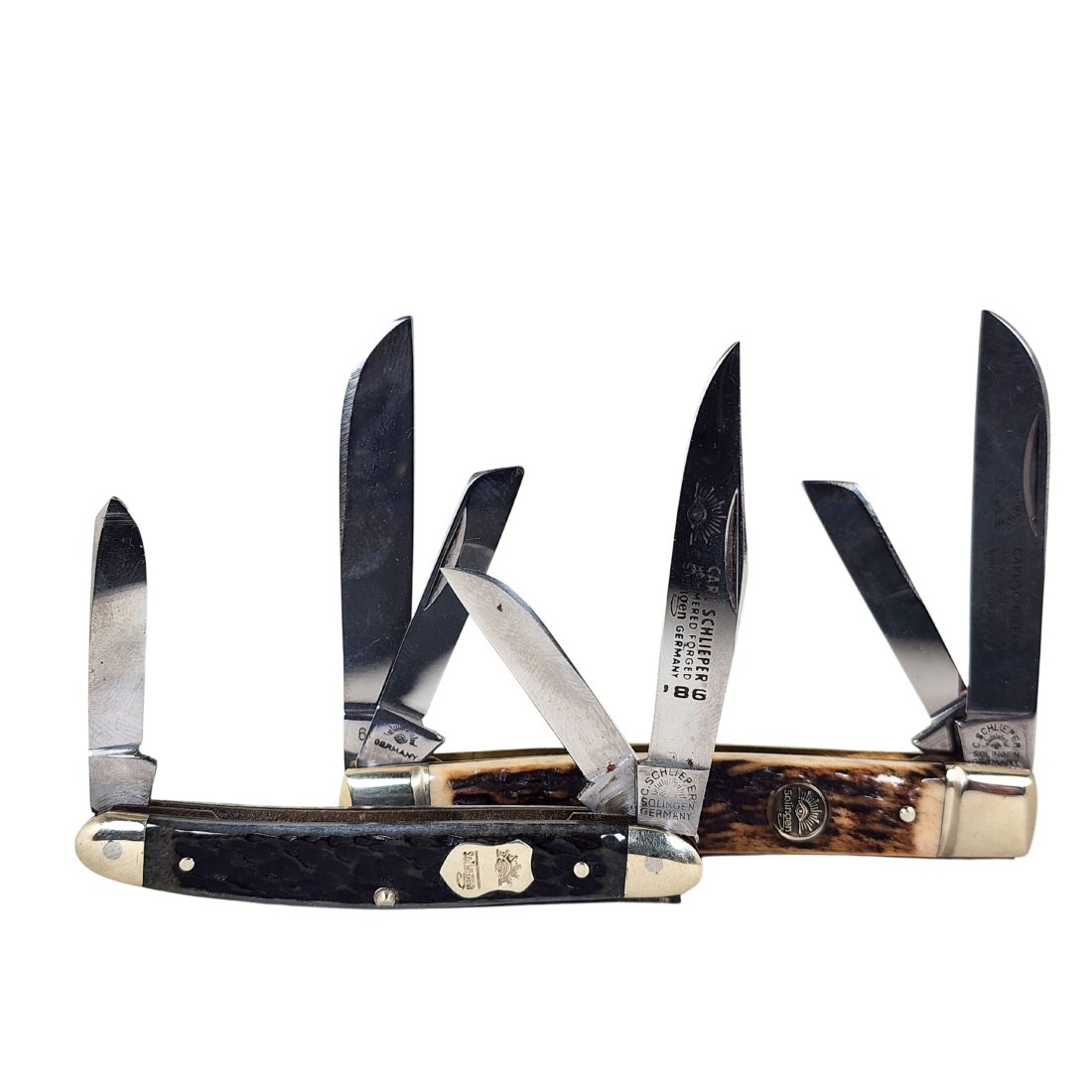 Carl Schlieper Germany Solingen Eye Logo Pocket Knives: Two vintage Carl Schlieper eye logo pocket knives with etched blades. 60DS stag handle 4 blade and black bone 1986 3 blade. Measures 3 1/4" to 4 1/4" closed.