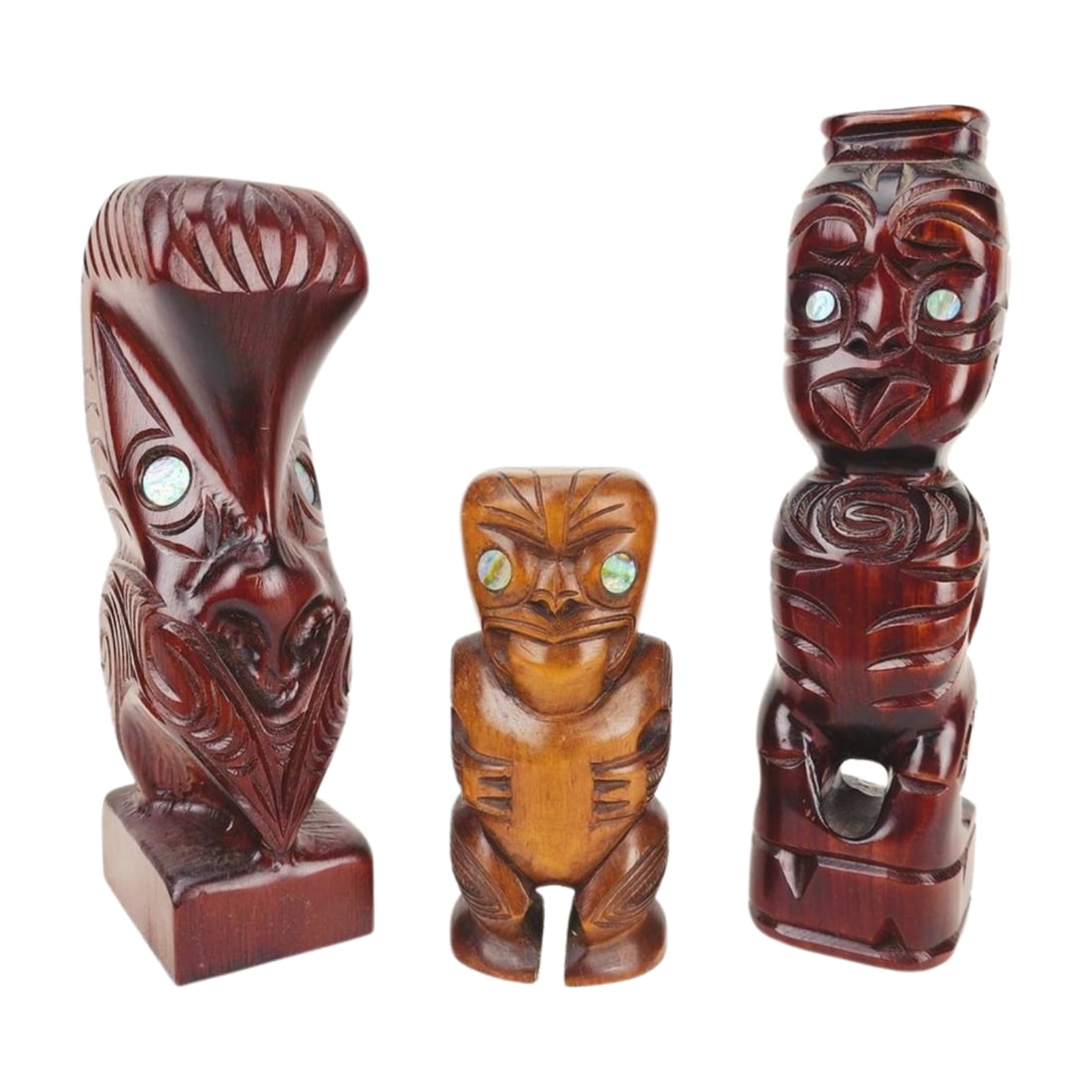 Group of 3 Wood Carved Tiki Statues: Group of vintage wood carved Tiki statues with paua shell eyes in various sizes, deities and wood. Measure 6" to 10 3/4".