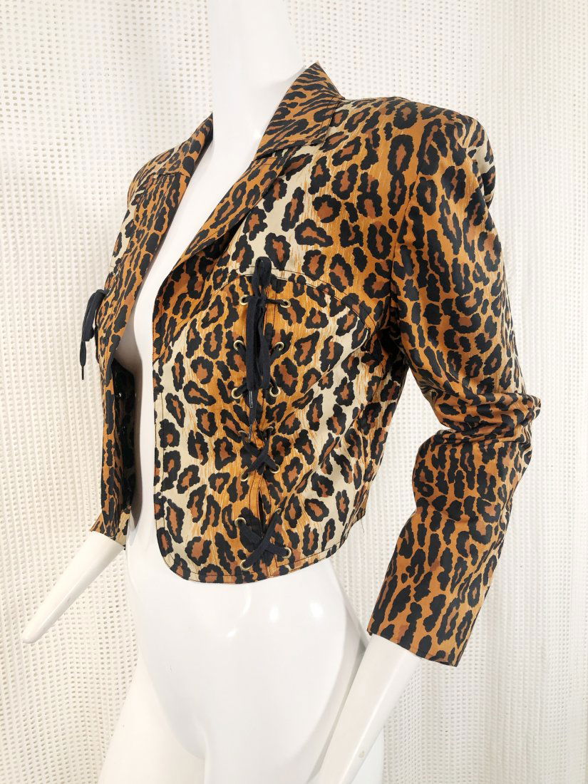 1980s Patrick Kelly Leopard Print Silk Bolero Jacket: A splashy 1980s Patrick Kelly leopard print silk cropped bolero jacket with structured shoulders and corset lacing and grommet front details.