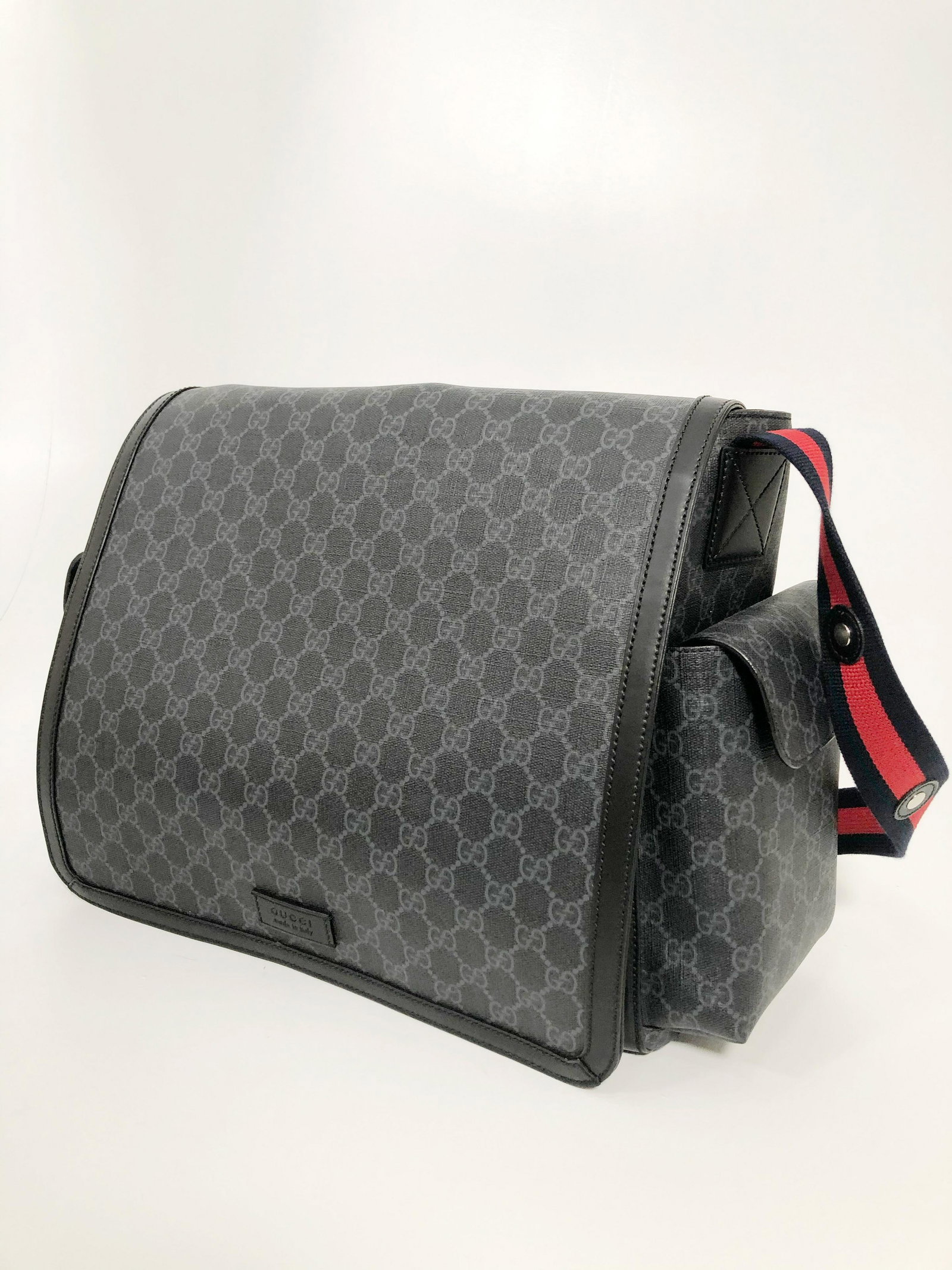Gucci Logo Navy and Grey Messenger Bag: Gucci logo navy and grey messenger bag w/ signature navy and red adjustable strap. Black trim. Decorative rivets on strap. Measures: 13"H X 5.75"D X 15"W Handbag drop: Adjustable