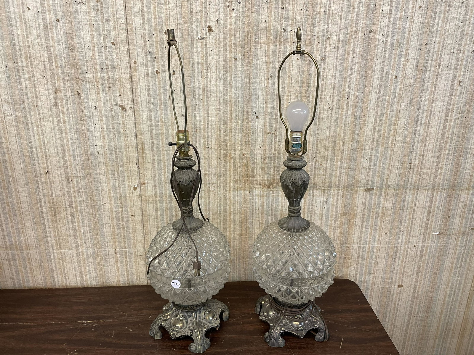 Pair Of 1960's Glass & Metal Table Lamps: Lamps have a round glass center with geometric expressions & ornate metal frames. Measure 33" H to finial.