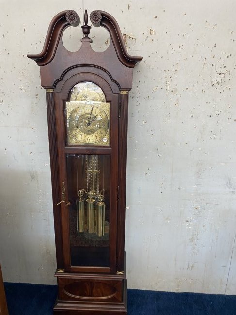 Howard Miller Grandfathers Clock: Signed on the works. Includes key & pendulum. Beveled glass. Measures 84" x 24".