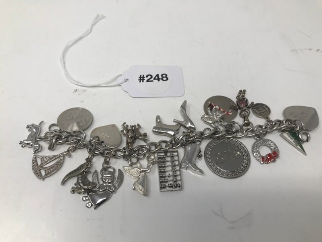 Sterling Charm Bracelet: Has boots, angel, and various other charms. Measures approximately 6" in length. Marked Sterling.