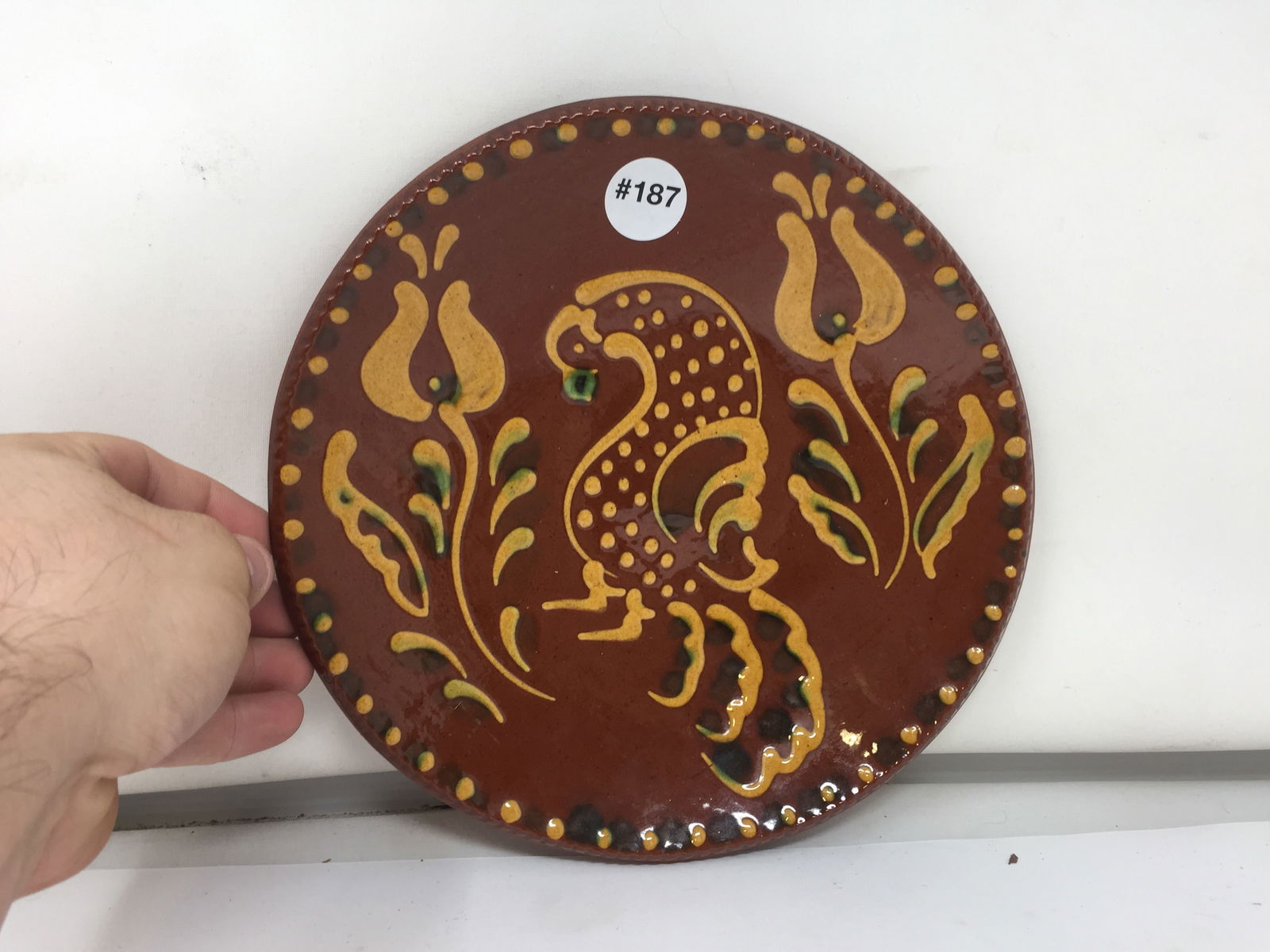 Foltz Redware Plate: tulip and preening bird design, marked on back. 10"W.