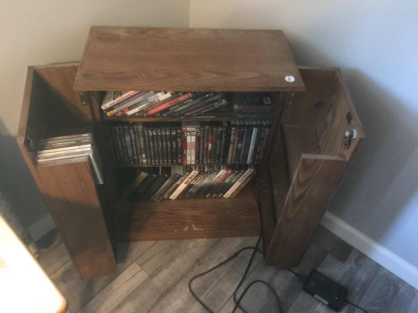 DVD Cabinet w/Contents: oak cabinet 29" x 23". Includes dvd's, vhs, plus.