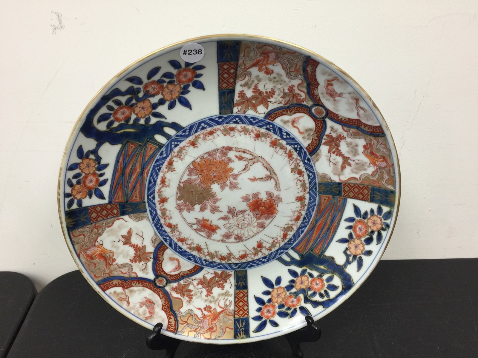 Japanese Imari Charger: overglaze enamel, with floral and landscape design with dragon in the sky motif and phoenix designs. 16"W.