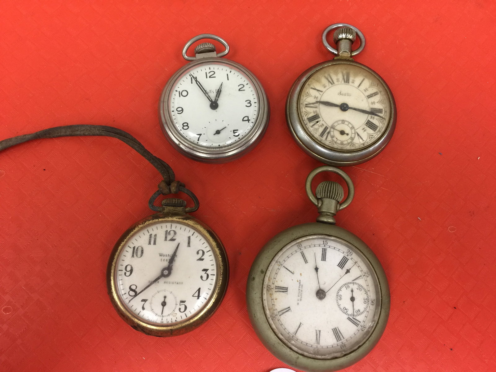 Pocket Watch Grouping (4): includes sears (locomotive engraving on back), ny standard watch co. (locomotive engraving on back), westclox in brass case and bulls eye.