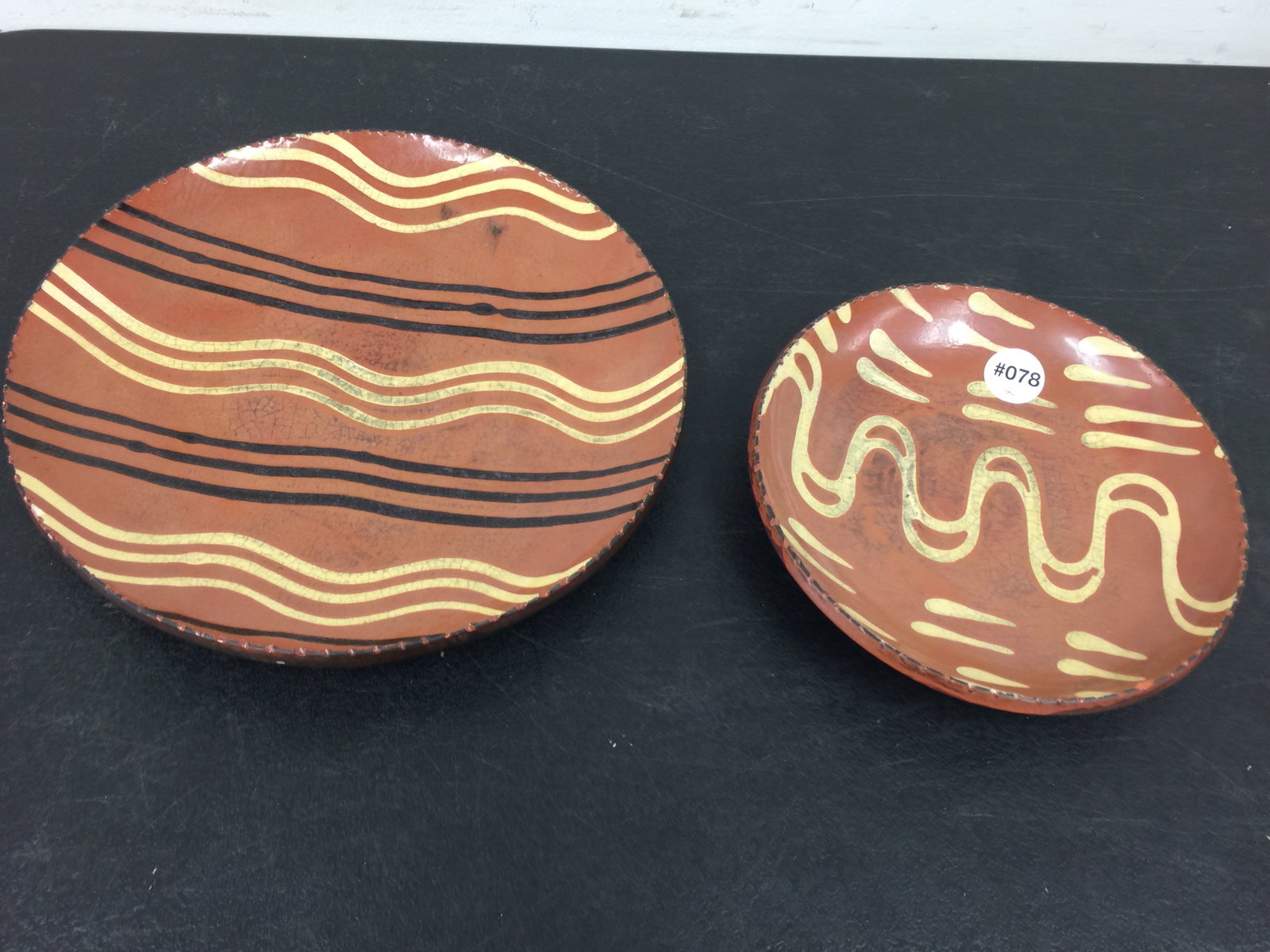 2 Turtle Creek Redware Plates: Largest 10" W. One signed Betty Lou, other Christopher Woods.